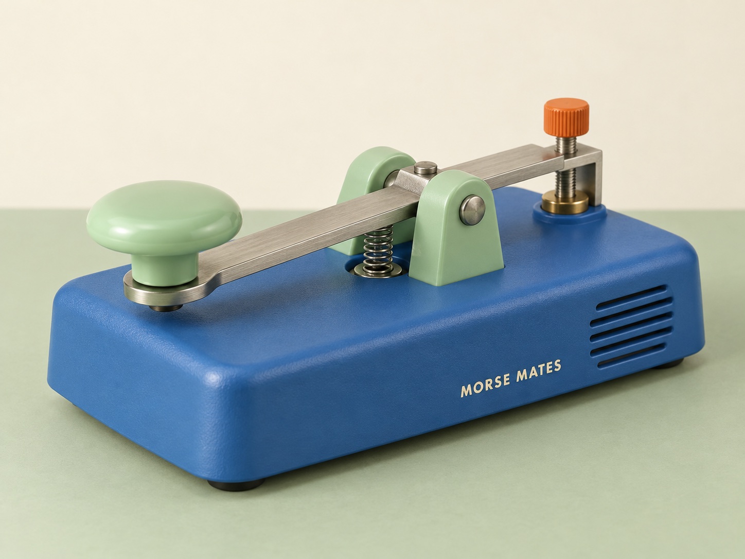 Three-quarter studio view of the blue and mint Morse Mates key with its metal lever, return spring, orange adjustment screw, and sounder grille